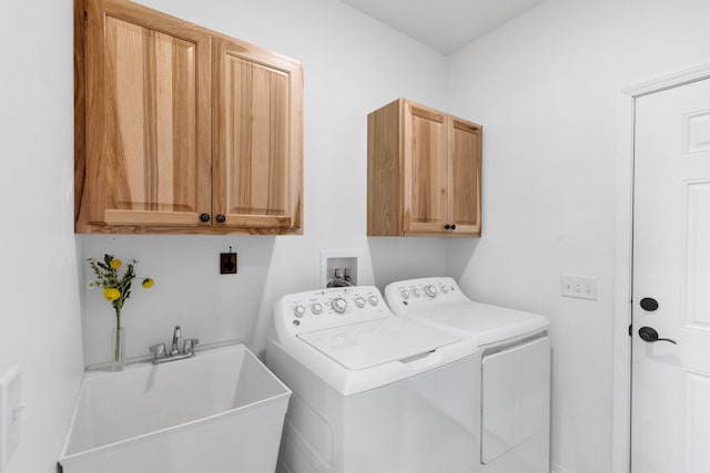 laundry room featuring washer and clothes dryer, cabinet space, and a sink