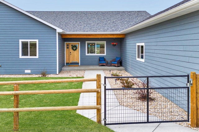 view of exterior entry with a gate, fence, a shingled roof, and covered porch