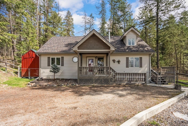 343 Deer Trl, Whitefish, MT 59937 - view of front of property featuring a wooden deck, a shingled roof, and fence