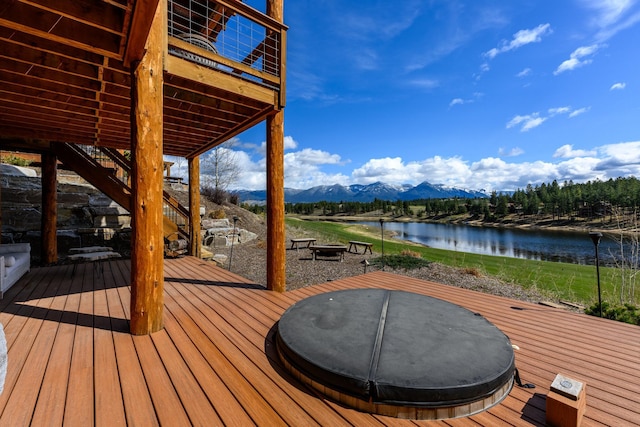 wooden deck with a fire pit, stairway, and a water and mountain view