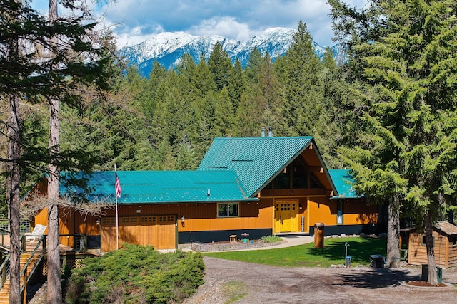 view of front facade featuring a forest view, a mountain view, and metal roof