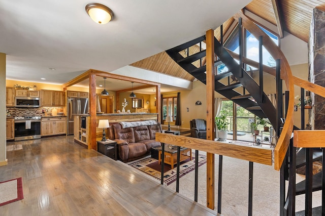 living room featuring high vaulted ceiling, stairway, and dark wood-style flooring