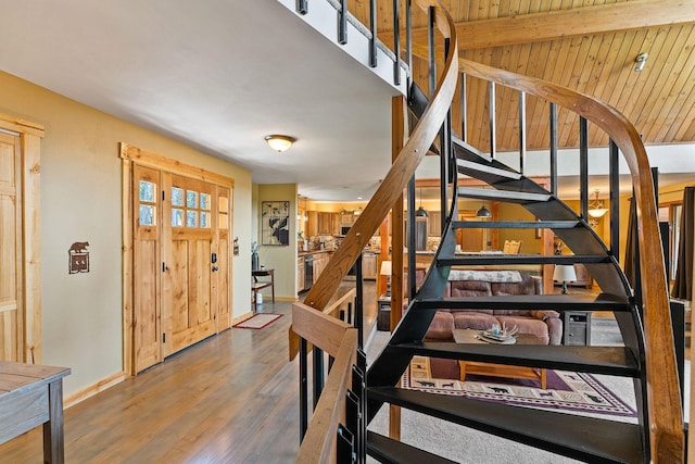 staircase featuring wood finished floors and baseboards