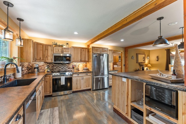 kitchen featuring dark countertops, a sink, decorative backsplash, stainless steel appliances, and dark wood finished floors