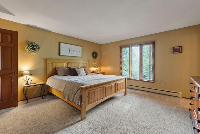 bedroom featuring a baseboard heating unit, light carpet, and baseboards