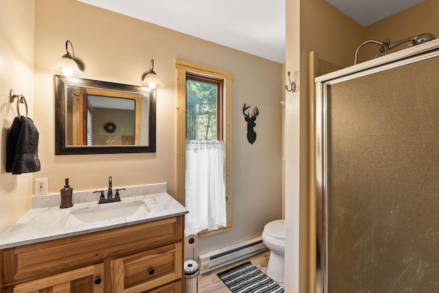 full bathroom featuring a shower stall, wood finished floors, a baseboard heating unit, vanity, and toilet