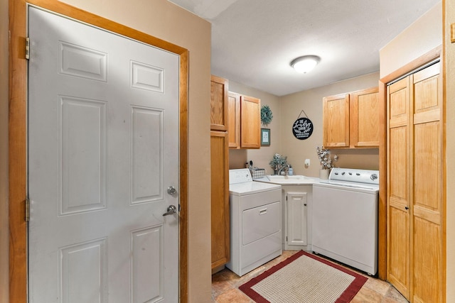 clothes washing area with washing machine and dryer, cabinet space, and light tile patterned floors