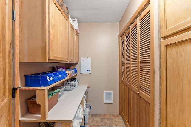 washroom featuring stone finish flooring and visible vents