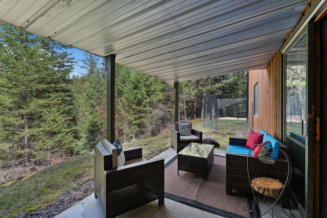view of patio featuring a view of trees, fence, and an outdoor living space