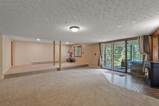 below grade area featuring baseboards, baseboard heating, carpet flooring, and a wood stove