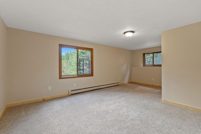 unfurnished room with a baseboard radiator, baseboards, and light carpet