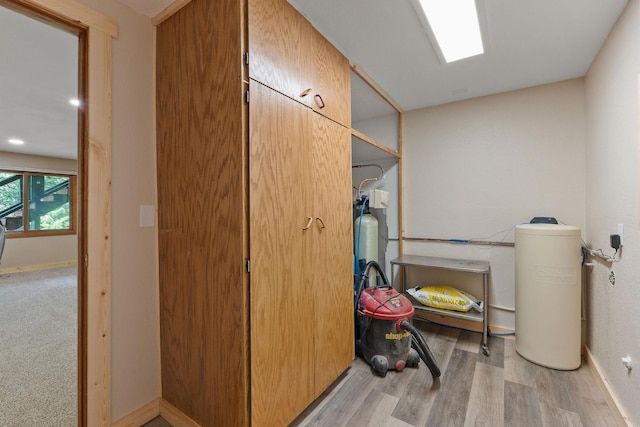 laundry room featuring baseboards and wood finished floors