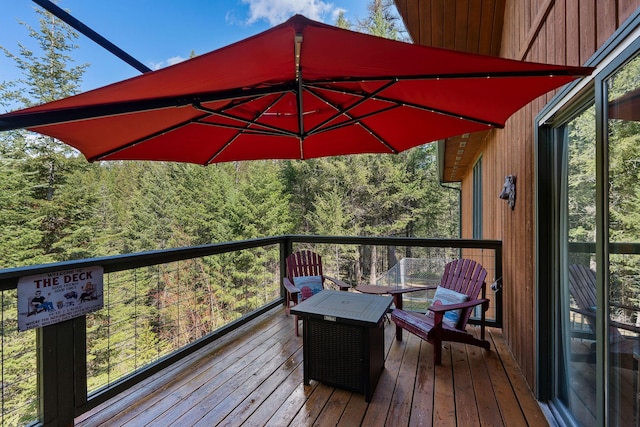 wooden terrace featuring a forest view