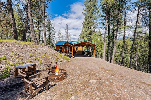view of front of house with a fire pit and dirt driveway
