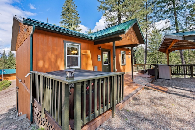 back of property with metal roof and a deck