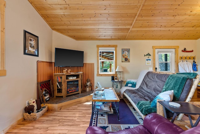 living area featuring a glass covered fireplace, wood finished floors, lofted ceiling, and wooden ceiling