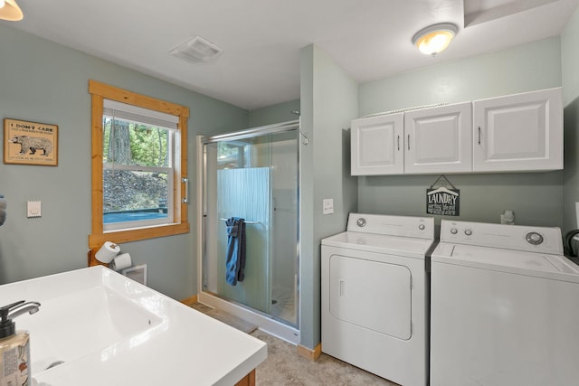 laundry area with visible vents, a sink, washing machine and clothes dryer, baseboards, and cabinet space