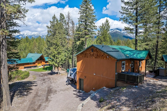 view of side of property with a mountain view and metal roof