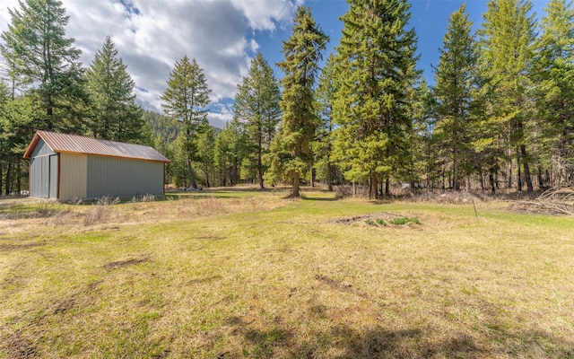 1298 E Mountain Meadow Rd, Kalispell, MT 59901 - view of grassy yard with an outdoor structure and a forest view
