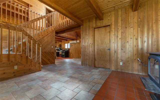 1298 E Mountain Meadow Rd, Kalispell, MT 59901 - unfurnished living room featuring wood walls, a wood ceiling with exposed beams, stone tile flooring, stairway, and a wall mounted AC