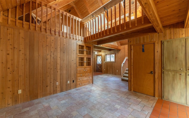 1298 E Mountain Meadow Rd, Kalispell, MT 59901 - unfurnished living room with wooden walls, stone tile floors, and stairway