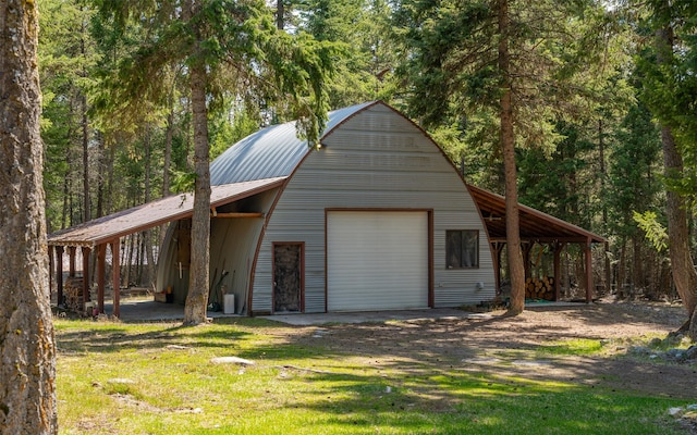 1298 E Mountain Meadow Rd, Kalispell, MT 59901 - view of front of house with a garage, an outbuilding, a front yard, driveway, and a metal roof