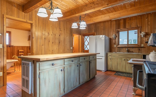 1298 E Mountain Meadow Rd, Kalispell, MT 59901 - kitchen featuring a chandelier, freestanding refrigerator, wood counters, a wooden ceiling with exposed beams, and wooden walls
