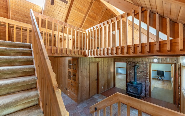 1298 E Mountain Meadow Rd, Kalispell, MT 59901 - stairs with a wood stove, high vaulted ceiling, and a wooden ceiling with exposed beams