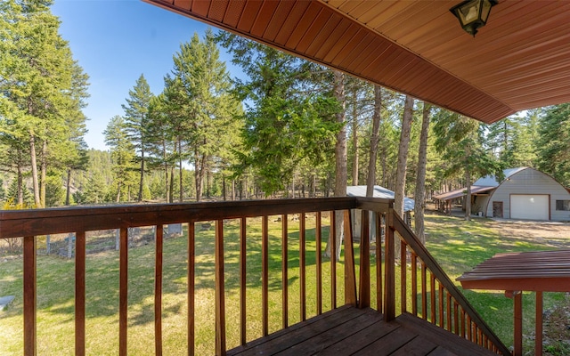 1298 E Mountain Meadow Rd, Kalispell, MT 59901 - deck featuring a garage, a yard, view of scattered trees, and an outdoor structure