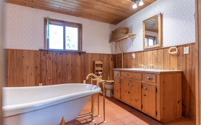 1298 E Mountain Meadow Rd, Kalispell, MT 59901 - bathroom with wainscoting, wood walls, wallpapered walls, a freestanding tub, and vanity
