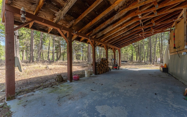 1298 E Mountain Meadow Rd, Kalispell, MT 59901 - view of patio featuring an attached carport and a wooded view
