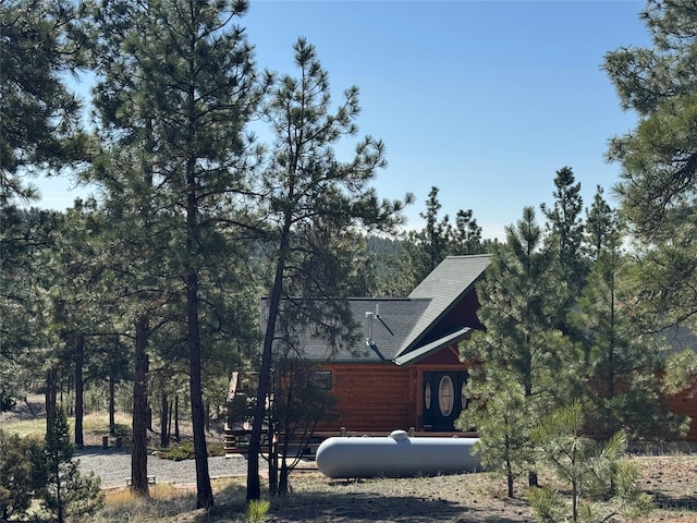 view of side of home with roof with shingles