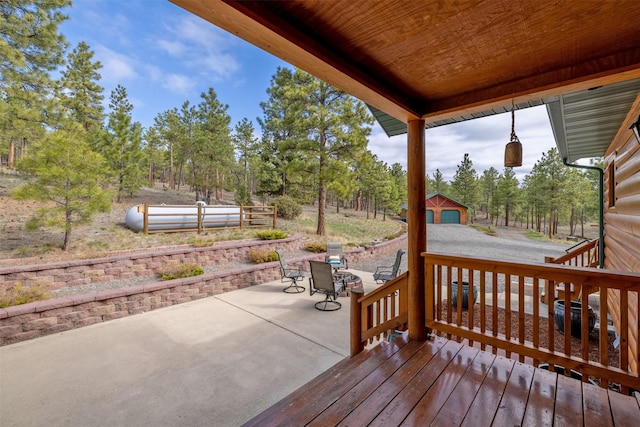 wooden terrace featuring a patio, outdoor dining area, and an outdoor structure