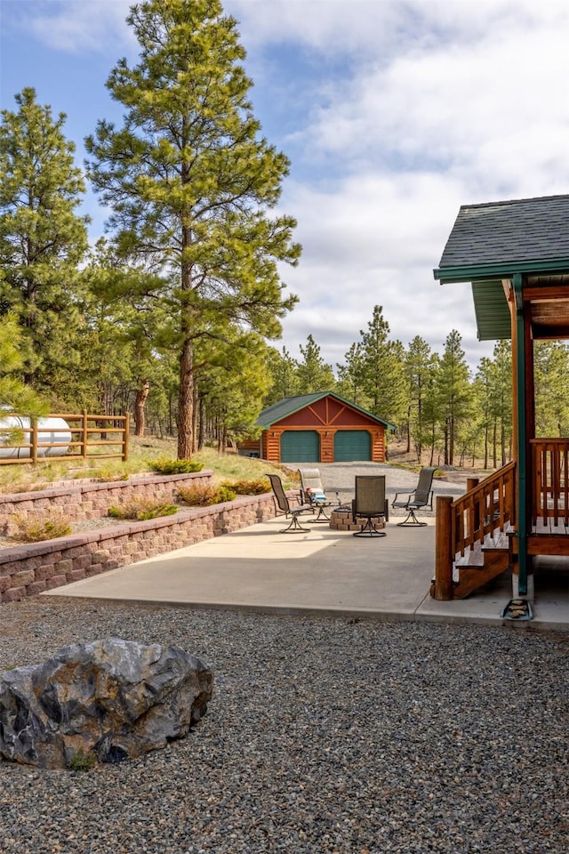 view of patio with an outdoor fire pit, an outbuilding, and a detached garage