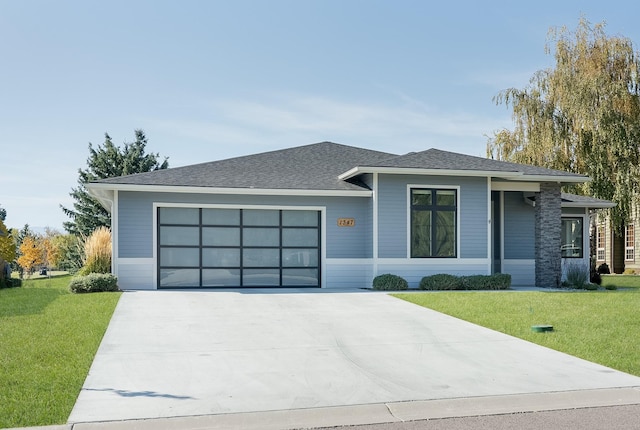 1347 Lake Pointe Dr, Bigfork, MT 59911 - prairie-style house featuring a garage, a front lawn, concrete driveway, and a shingled roof