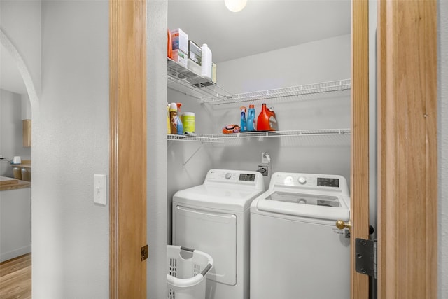 3404 Jasper Rd, Great Falls, MT 59404 - laundry area featuring washer and dryer, arched walkways, and wood finished floors