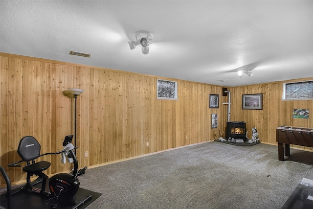 3404 Jasper Rd, Great Falls, MT 59404 - game room featuring a wood stove, carpet flooring, and wood walls