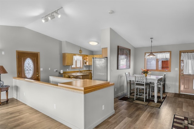 3404 Jasper Rd, Great Falls, MT 59404 - kitchen featuring freestanding refrigerator, lofted ceiling, wood finished floors, pendant lighting, and track lighting
