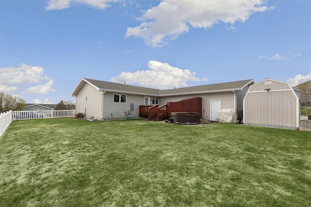 3404 Jasper Rd, Great Falls, MT 59404 - back of house featuring a hot tub, a fenced backyard, and a storage unit