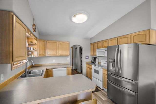 3404 Jasper Rd, Great Falls, MT 59404 - kitchen with white appliances, lofted ceiling, arched walkways, light brown cabinets, and a peninsula
