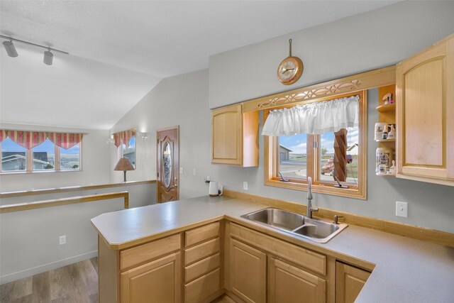 3404 Jasper Rd, Great Falls, MT 59404 - kitchen with light countertops, a peninsula, lofted ceiling, wood finished floors, and light brown cabinets