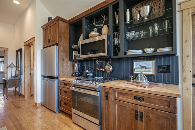 160 Jackson Creek Rd, Clancy, MT 59634 - kitchen with appliances with stainless steel finishes, open shelves, light wood-type flooring, brown cabinets, and wooden counters