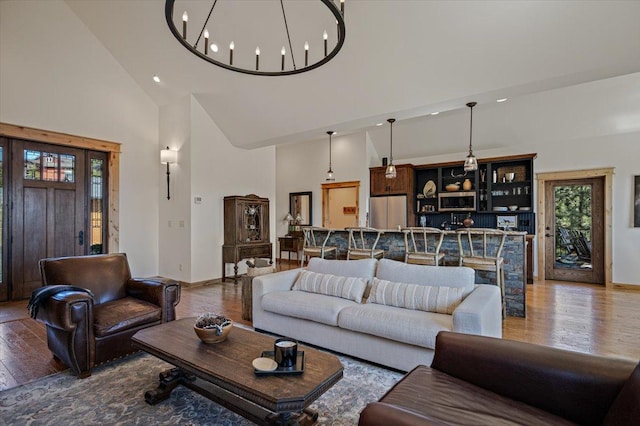 160 Jackson Creek Rd, Clancy, MT 59634 - living room featuring high vaulted ceiling, wood finished floors, and a chandelier