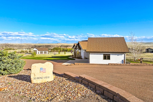 10 Bend View Ln, Great Falls, MT 59404 - view of home's exterior featuring an outdoor structure, board and batten siding, and roof with shingles