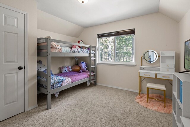 carpeted bedroom with baseboards and lofted ceiling