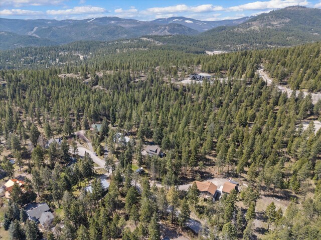 aerial view with a water and mountain view and a view of trees