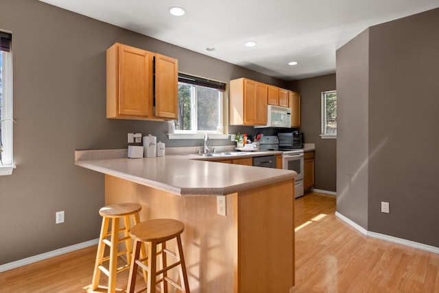116 Grandview Ter, Lakeside, MT 59922 - kitchen featuring white appliances, a sink, light wood-style floors, a breakfast bar, and recessed lighting