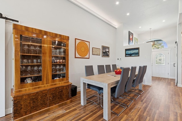 14 Buffalo Hill Cir, Kalispell, MT 59901 - dining space featuring wood finished floors, a towering ceiling, recessed lighting, a barn door, and baseboards