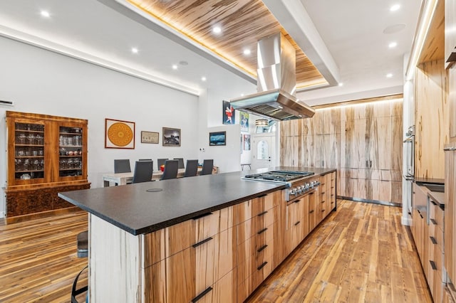 14 Buffalo Hill Cir, Kalispell, MT 59901 - kitchen featuring stainless steel gas cooktop, modern cabinets, dark countertops, island range hood, and recessed lighting