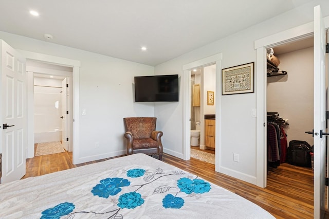 14 Buffalo Hill Cir, Kalispell, MT 59901 - bedroom featuring a walk in closet, wood finished floors, ensuite bathroom, baseboards, and recessed lighting